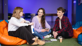 Kontynuuj studia | Uniwersytet WSB Merito Bydgoszcz: Główna grafika: Kontynuuj studia - Uniwersytet WSB Merito Bydgoszcz - studenci spędzają wspólnie czas między zajęciami w strefie studenta na uczelni