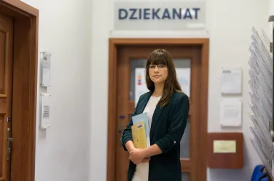 ABC studenta | Uniwersytet WSB Merito Bydgoszcz: studentka przed dziekanatem Uniwersytetu WSB Merito Bydgoszcz