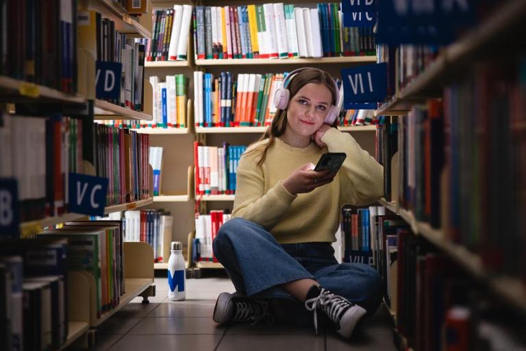 Stypendia i zniżki | Uniwersytet WSB Merito Bydgoszcz: studentka w bibliotece Uniwersytetu WSB Merito Bydgoszcz