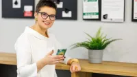 Zarządzanie zasobami ludzkimi - specjalista HR | Studia podyplomowe w Chorzowie | Uniwersytet WSB Merito Chorzów: studentka z telefonem