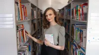 Psychologia w HR | Studia I stopnia w Chorzowie | Uniwersytet WSB Merito Chorzów: studentka przegląda książki w bibliotece