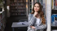 Menedżer HR | Studia II stopnia w Chorzowie | Uniwersytet WSB Merito Chorzów: Studentka stojąca w bibliotece 