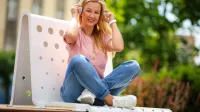 Psychoneuroimmunologia (PNI) | Studia podyplomowe w Chorzowie | Uniwersytet WSB Merito Chorzów: Studentka WSB Merito siedzi na ławce w plenerze i słucha muzyki przez słuchawki