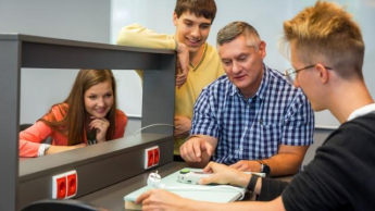 Inteligentne systemy logistyczne | Studia I stopnia w Chorzowie | Uniwersytet WSB Merito Chorzów: studenci omawiający użycie urządzenia