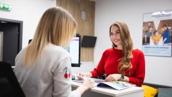 Zarządzanie sprzedażą | Studia I stopnia w Chorzowie | Uniwersytet WSB Merito Chorzów: studentka rozmawiająca z pracownikiem działu rekrutacji