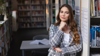 Menedżer HR | Studia II stopnia w Chorzowie | Uniwersytet WSB Merito Chorzów: Studentka stojąca w bibliotece 
