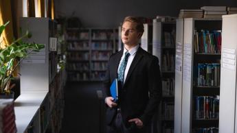Pracownik służby cywilnej | Studia I stopnia w Chorzowie | Uniwersytet WSB Merito Chorzów: Student stojący w bibliotece