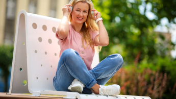 Psychoneuroimmunologia (PNI) | Studia podyplomowe w Chorzowie | Uniwersytet WSB Merito Chorzów: Studentka WSB Merito siedzi na ławce w plenerze i słucha muzyki przez słuchawki
