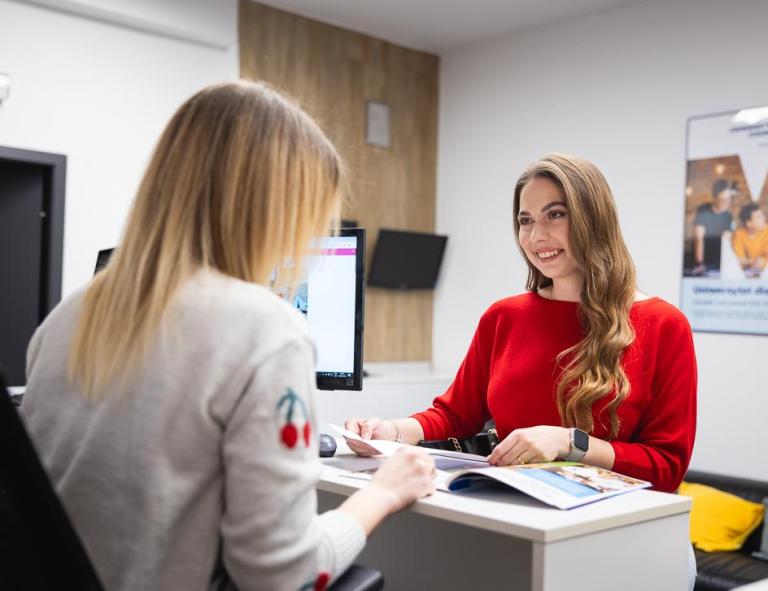 Administracja publiczna | Studia I stopnia w Chorzowie | Uniwersytet WSB Merito Chorzów: studentka rozmawiająca z pracownikiem działu rekrutacji