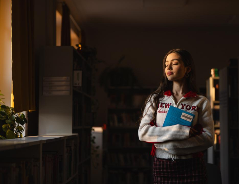Zarządzanie projektami | Studia I stopnia w Chorzowie | Uniwersytet WSB Merito Chorzów: Studentka stojąca w bibliotece