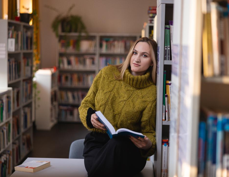 Finanse i rachunkowość | Studia II stopnia w Chorzowie | Uniwersytet WSB Merito Chorzów: studentka przeglądająca książki w bibliotece 