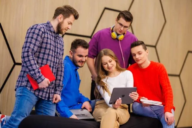 Business English with German | Uniwersytet WSB Merito Chorzów: studenci oglądający coś na tablecie