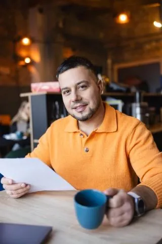 Prawo i finanse | Studia I stopnia w Chorzowie | Uniwersytet WSB Merito Chorzów: student z kawą i notatkami