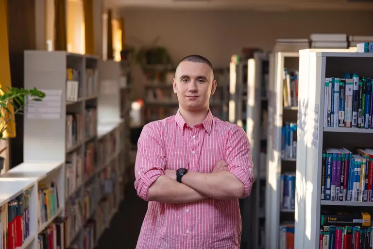 Gospodarowanie nieruchomościami | Studia II stopnia w Chorzowie | Uniwersytet WSB Merito Chorzów: student studiów licencjackich stojący w bibliotece