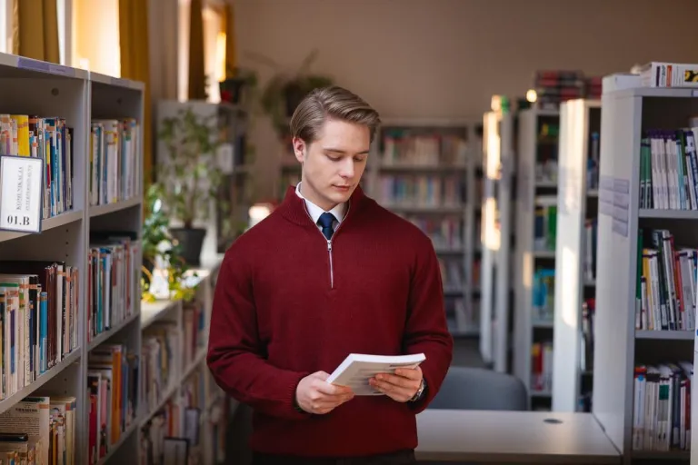 Psychologia śledcza i sądowa | Studia jednolite magisterskie w Chorzowie | Uniwersytet WSB Merito Chorzów: Student przeglądający książkę w bibliotece