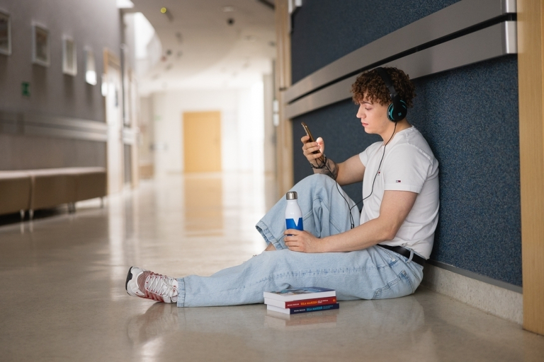 Language certificates | WSB Merito Bydgoszcz University: A student sitting on the Uni floor