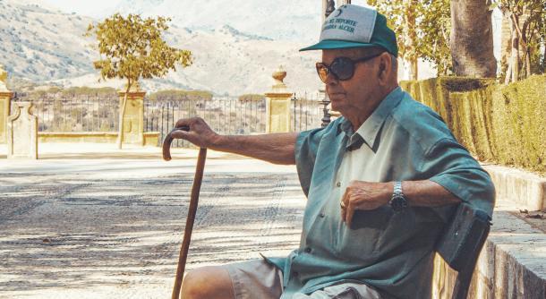 man tourist hat style bench sitting glasses older man