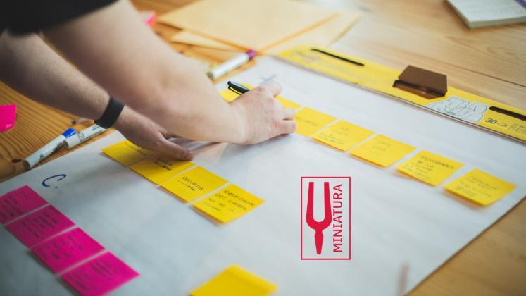miniatura project plan hands sticky notes