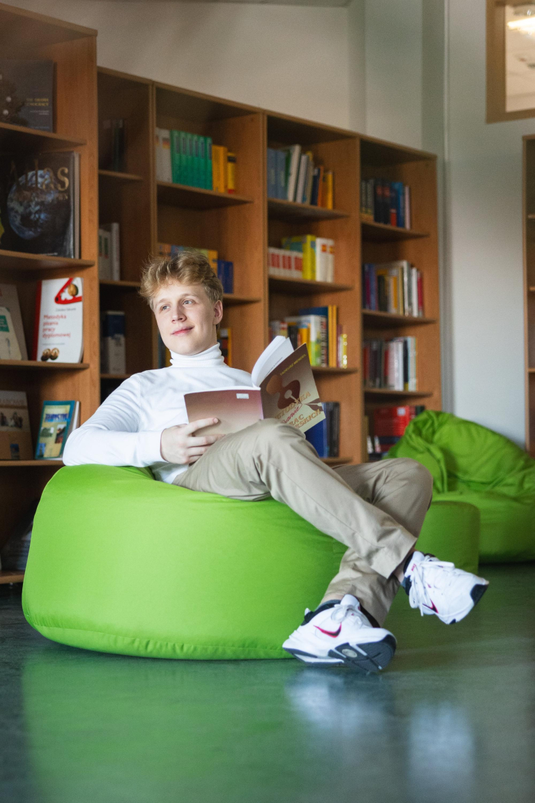 Student Zone | WSB Merito Łódź University: Uczeń czyta książkę w bibliotece Uniwersytetu WSB Merito w Łodzi