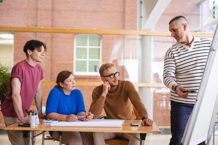 Our values | WSB Merito Poznań University: studenci przy biurku, Poznań
