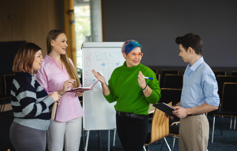 grupa studentów przy tablicy typu flipchart