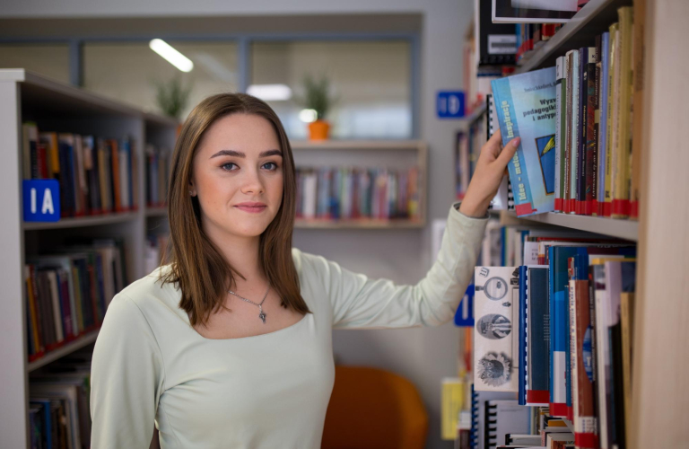 Search results | WSB Merito Toruń University: studentka w bibliotece przy regale z książkami