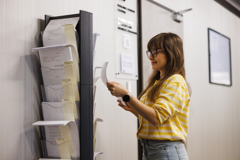 Student's Office | WSB Merito Wrocław University: studentka pobierająca wniosek przy dziekanacie