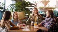 Grupa studentów w wolnym czasie siedzi przy stoliku w restauracji 