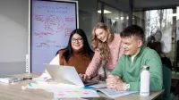 Wyniki wyszukiwania | Uniwersytet WSB Merito w Gdańsku: Studenci w bibliotece siedzą przy biurku i opracowują jakieś zagadnienie przy laptopie