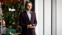International business | Studia I stopnia w Gdańsku | Uniwersytet WSB Merito w Gdańsku: Zdjęcie biznesowe studenta w garniturze z komórką w rękach