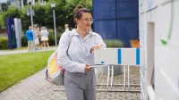 Zarządzanie nieruchomościami i pośrednictwo | Studia I stopnia w Gdańsku | Uniwersytet WSB Merito w Gdańsku: Studentka wkładająca książkę do książkomatu