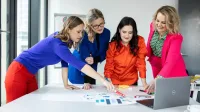 Zarządzanie jakością w branży automotive | Studia podyplomowe w Gdańsku | Uniwersytet WSB Merito w Gdańsku: Kobiety przy stole z laptopem pracują nad zagadnieniem