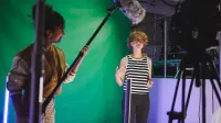 Komunikacja cyfrowa i media kreatywne | Studia II stopnia ze studiami podyplomowymi w Gdańsku | Uniwersytet WSB Merito w Gdańsku: Studentka w studio z green screenem podczas nagrania