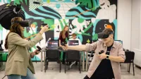 Robotyzacja i automatyzacja procesów wytwarzania – Industry 4.0 | Studia I stopnia w Gdańsku | Uniwersytet WSB Merito w Gdańsku: Studenci z googlami VR w przestrzeni z fototapetą