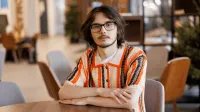 Filologia angielska z językiem i kulturą norweską | Studia II stopnia w Gdańsku | Uniwersytet WSB Merito w Gdańsku: Student w ciemnych okularach i długich włosach