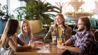 Grupa studentów w wolnym czasie siedzi przy stoliku w restauracji 