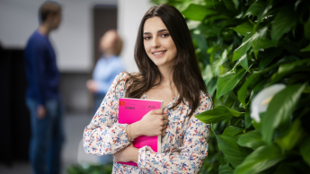 Wyniki wyszukiwania | Uniwersytet WSB Merito w Gdańsku: Studentka przy zielonej ścianie z książką w ręku
