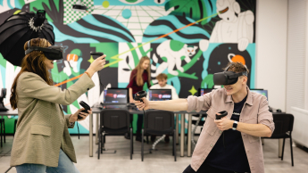 Robotyzacja i automatyzacja procesów wytwarzania – Industry 4.0 | Studia I stopnia w Gdańsku | Uniwersytet WSB Merito w Gdańsku: Studenci z googlami VR w przestrzeni z fototapetą