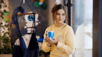 Smart Marketing | Studia II stopnia w Gdańsku | Uniwersytet WSB Merito w Gdańsku: Studentka w strefie studenta z kubkiem w dłoni