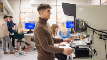 Drony i technologie bezzałogowe w obszarze bezpieczeństwa | Studia I stopnia w Gdańsku | Uniwersytet WSB Merito w Gdańsku: Student podczas warsztatów przy sprzęcie