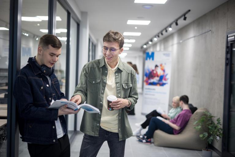 Bezpieczeństwo militarne | Studia I stopnia w Gdańsku | Uniwersytet WSB Merito w Gdańsku: Studenci stoją w korytarzu i uczą się na zajęcia