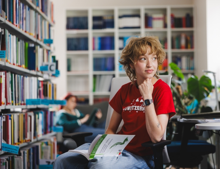 Psychologia w marketingu | Studia II stopnia w Gdańsku | Uniwersytet WSB Merito w Gdańsku: Studentka czyta książkę w bibliotece