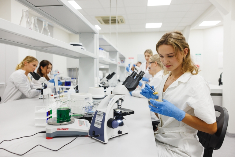 Kosmetologia | Studia II stopnia w Gdańsku | Uniwersytet WSB Merito w Gdańsku: Studentka podczas warsztatów w laboratorium z mikroskopami