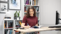 Rachunkowość i finanse przedsiębiorstw | Studia I stopnia w Gdyni | Uniwersytet WSB Merito Gdynia: Dziewczyna siedzi w przestrzeni biurowej i robi notatki