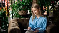 IT project management | Studia II stopnia w Gdyni | Uniwersytet WSB Merito Gdynia: Studentka siedzi na fotelu i pisze w zeszycie