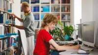 Cyberbezpieczeństwo i ochrona danych w Administracji | Studia I stopnia w Gdyni | Uniwersytet WSB Merito Gdynia: Studentka przy komputerze w bibliotece