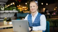 Bezpieczeństwo systemów informatycznych | Studia I stopnia w Gdyni | Uniwersytet WSB Merito Gdynia: Student w biznesowym stroju w kawiarni przy laptopie