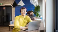 Planowanie produkcji – nowoczesne   narzędzia: SAP S/4HANA, Siemens Opcenter APS | Uniwersytet WSB Merito Gdynia: Student przy laptopie w strefie studenta