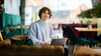 Terapia pedagogiczna z elementami arteterapii | Studia I stopnia w Gdyni | Uniwersytet WSB Merito Gdynia: Student w kawiarni przy laptopie