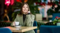 Projektowanie i aranżacja wnętrz | Studia podyplomowe w Gdyni | Uniwersytet WSB Merito Gdynia: Studentka w kawiarni z kawą w ręku 